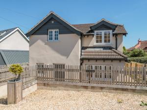 Casa blanca con valla de madera en The Coach House, en Lyme Regis