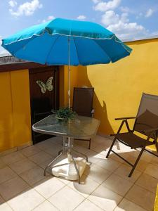 a table with a blue umbrella and two chairs at Spreewald Ferienwohnung Wollgast in Lübben