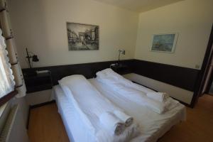 1 dormitorio con 1 cama con sábanas blancas y toallas en Egtved Hotel, en Egtved
