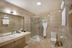 a bathroom with a shower and a toilet and a sink at Park Hotel and SPA Vella Hills in Velingrad