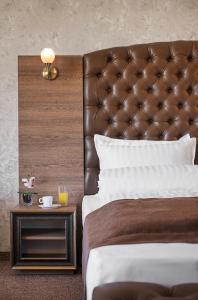 a bed with a leather headboard and a side table at Park Hotel and SPA Vella Hills in Velingrad