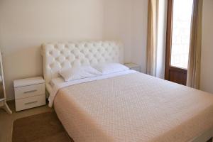 a bedroom with a large white bed and a window at Kazanegra Exclusive Apartments in Sveti Stefan