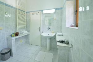 a white bathroom with a sink and a shower at Kazanegra Exclusive Apartments in Sveti Stefan