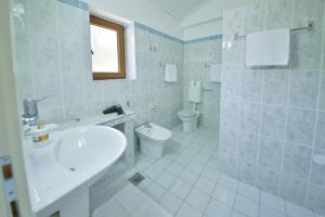a white bathroom with a sink and a toilet at Kazanegra Exclusive Apartments in Sveti Stefan