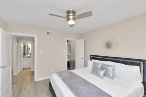 a white bedroom with a bed with a ceiling fan at Luxury King w/Resort-style Pool, Wi-Fi & Parking in Houston
