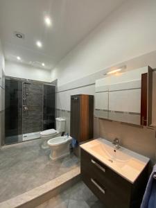 a bathroom with a toilet and a sink and a shower at Marechiaro Apartments in Palermo