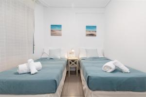 2 camas individuales en una habitación con mesa en Patacona Breeze, en Valencia