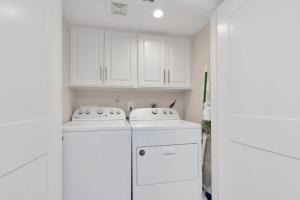 a kitchen with white cabinets and a washer and dryer at Luxury King w/Resort-style Pool, Wi-Fi & Parking in Houston