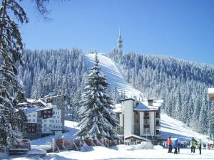 una estación de esquí con un árbol de Navidad en la nieve en Luxe Apartment Grand Monastery in Pamporovo, en Pamporovo