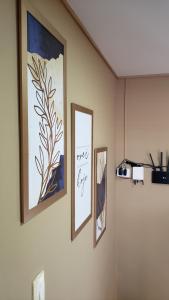 trois tableaux accrochés au mur d'une pièce dans l'établissement EnseadaPrime hospedagem beira-mar na Praia Enseada dos Corais em PE, à Cabo de Santo Agostinho
