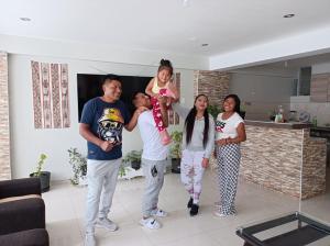 a group of people standing in a living room at Union Garden Apartments in Cusco