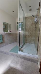 y baño con ducha y puerta de cristal. en Wellington Farm Devon near Heritage Coast beaches & AOBN- dog friendly en Honiton