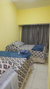 dwa łóżka siedzące obok siebie w pokoju w obiekcie EnseadaPrime hospedagem beira-mar na Praia Enseada dos Corais em PE w mieście Cabo de Santo Agostinho