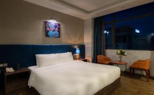Un dormitorio con una gran cama blanca y una ventana en Aaron Hotel, en Nha Trang