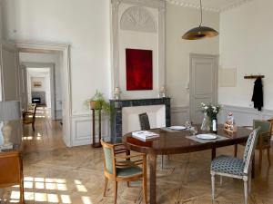 a dining room with a table and a fireplace at Hôtel Particulier, Maison Jazey. in Semur-en-Auxois