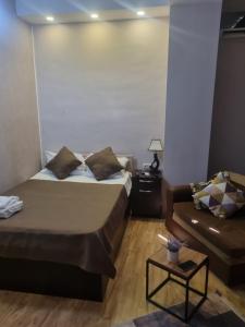 una camera d'albergo con due letti e un divano di Shatell a Tbilisi City