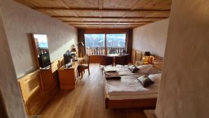 Habitación con cama, mesa y sillas. en Hotel Etrier en Crans-Montana