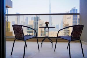 uma mesa e duas cadeiras em frente a uma janela em Luton Vacation Homes - Elite Residence Downtown, Burj Khalifa View, Dubai em Dubai