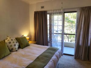 a bedroom with a bed and a large window at Eden Wilds 38 in Port Edward