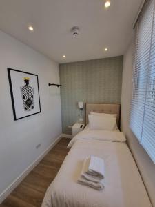 1 dormitorio con 1 cama con toallas en Hotel CG London, en Londres