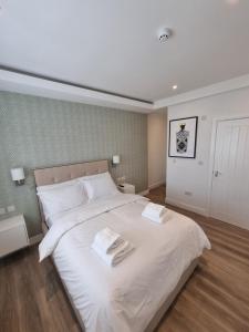 ロンドンにあるHotel CG Londonのベッドルーム1室(大きな白いベッド1台、タオル2枚付)