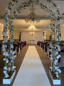 a wedding aisle with chairs and a chandelier at The Coleshill by Greene King Inns in Coleshill