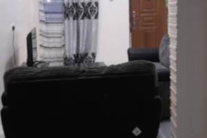 a reflection of a living room with a couch and a mirror at Bambino Guest House in Brikama