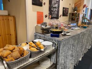 a buffet line with baskets of bread and pies at Schleswig Holstein Hotel in Elmshorn