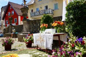 une table avec des fleurs devant un bâtiment dans l'établissement Gasthof zum Löwen, à Gößweinstein