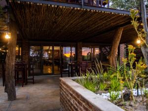 um restaurante com um telhado de madeira com mesas e cadeiras em Sian-simba-river-lodge em Victoria Falls