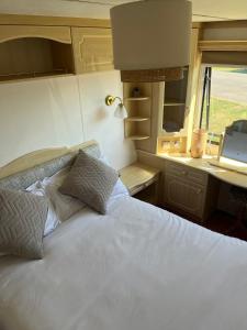 a bed in an rv with a laptop on it at Central Ingoldmells, Seaview 6 berth in Ingoldmells