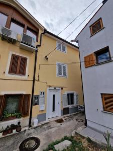 a yellow and white building next to a white building at Beautiful house Lanna in Izola