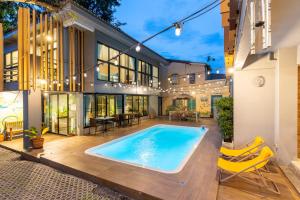 an exterior view of a house with a swimming pool at Nest by Sangob in Bangkok