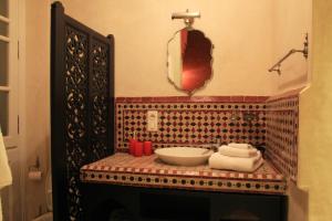 ein Badezimmer mit einer Theke mit einem Waschbecken und einem Spiegel in der Unterkunft Dar Souran in Tangier