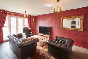 Sala de estar con 2 sofás de cuero y TV en Host & Stay - Greenfinch Road, en Coventry