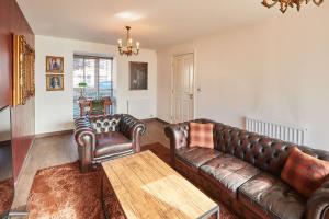 a living room with a leather couch and chairs at Host & Stay - Greenfinch Road in Coventry