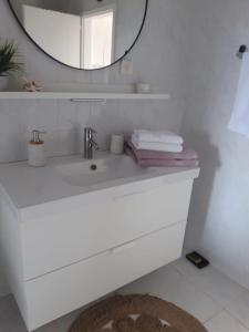 uma casa de banho branca com um lavatório e um espelho em Nina Sea View em Novi Vinodolski