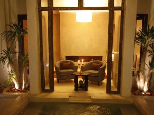 uma sala de estar com duas cadeiras e uma mesa com uma vela em Riad Vanilla Sma & Spa em Marrakech