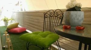 una mesa con un asiento acolchado verde junto a una mesa con un mantel en Central Location, en Nauplia