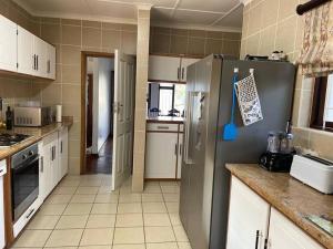 a kitchen with a stainless steel refrigerator and white cabinets at The Beach House in Port Shepstone