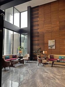 a lobby with couches and tables in a building at Velvet Hotel Jeddah in Jeddah