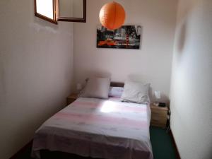 a small bedroom with a bed and an orange lamp at Madahouse in Gap