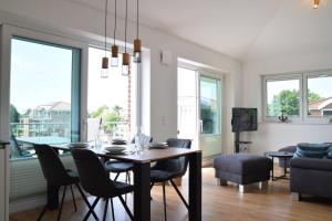 een eetkamer en een woonkamer met een tafel en stoelen bij Penthouse No 6 Haus Minsener Oog in Hooksiel
