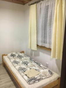 Cama en habitación con ventana en Domki Snopki en Pisz