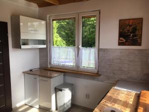a small kitchen with a window and a counter at Domki Snopki in Pisz