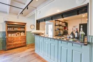 una cocina con armarios azules y un bar en Herberg de Loohoeve en Schoonloo