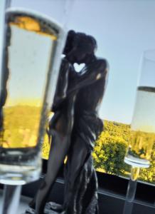 une statue d'une femme avec deux verres de vin dans l'établissement L'idyle loft érotique détente, à Callac