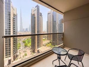 uma varanda com 2 cadeiras e vista para a cidade em Luton Vacation Homes - Elite Residence Downtown, Burj Khalifa View, Dubai em Dubai