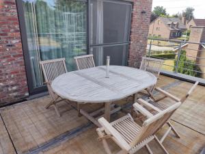 a wooden table and chairs on a patio with a window at Vakantiewoning Op Den Briel in Lokeren +4 photos