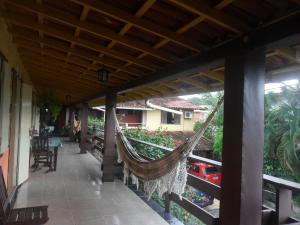 a hammock on the porch of a house at Pousada Recanto de Minas in Porto Seguro